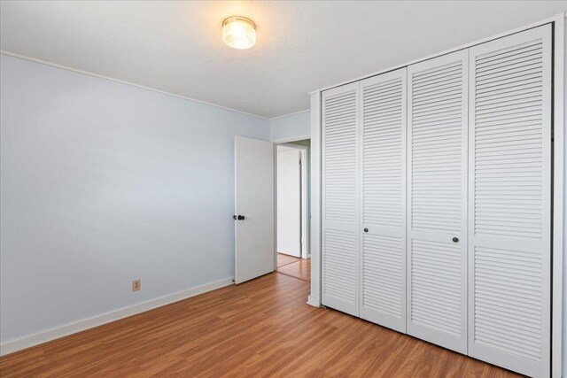 263 S Alu Rd, Wailuku, HI 96793 - unfurnished bedroom with light wood finished floors, a closet, and baseboards
