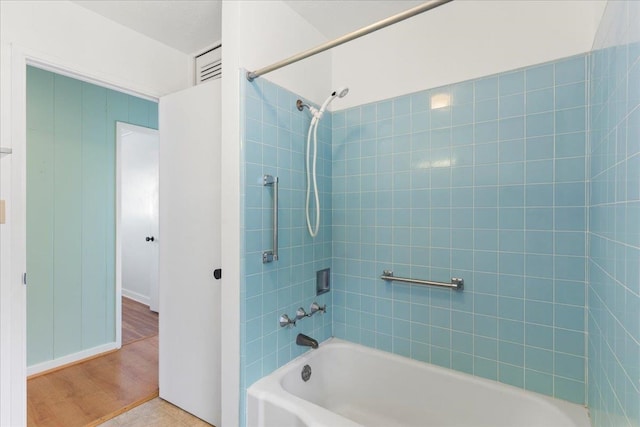 bathroom featuring hardwood / wood-style floors and tiled shower / bath