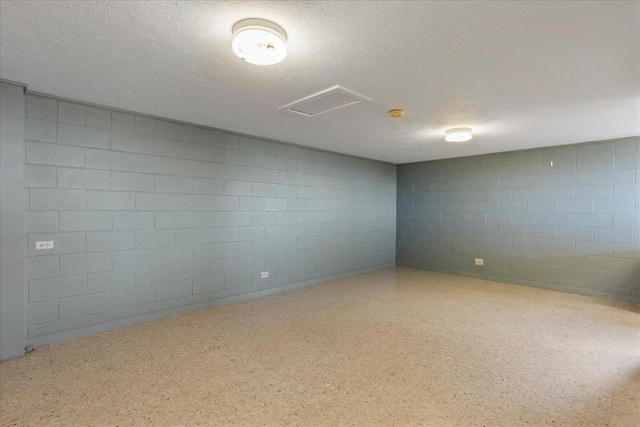 263 S Alu Rd, Wailuku, HI 96793 - empty room featuring concrete block wall, a textured ceiling, and attic access