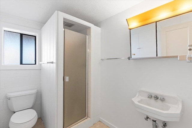 bathroom featuring sink, walk in shower, a textured ceiling, toilet, and tile walls