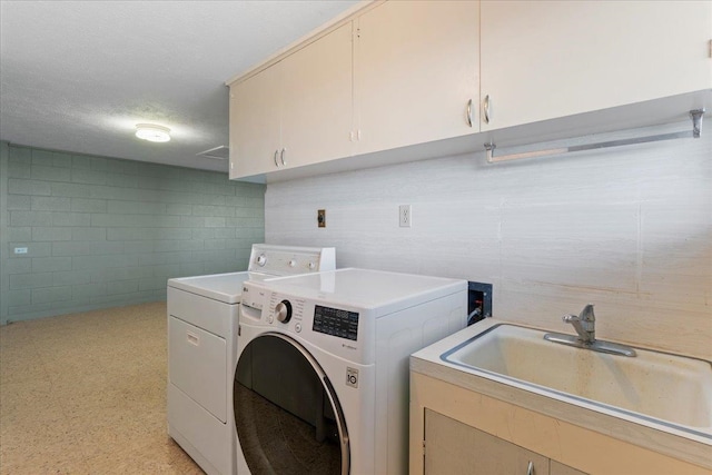 laundry area with separate washer and dryer, sink, cabinets, and a textured ceiling