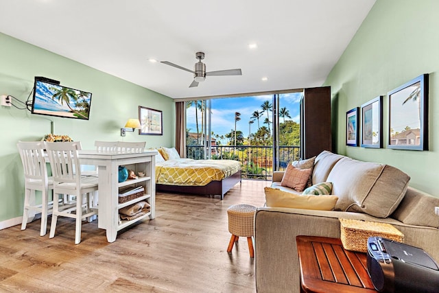 bedroom featuring expansive windows and light hardwood / wood-style floors