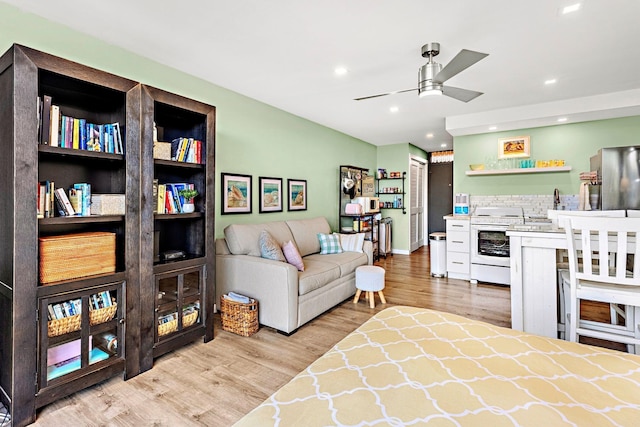 living room featuring ceiling fan and light hardwood / wood-style floors