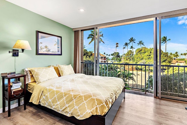 bedroom featuring hardwood / wood-style flooring, access to outside, and expansive windows