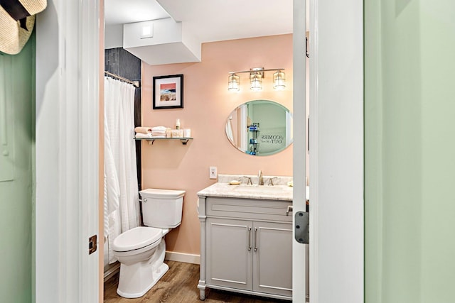 bathroom featuring vanity, toilet, curtained shower, and hardwood / wood-style floors