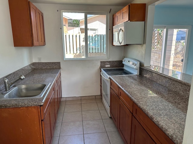 kitchen with sink, light tile patterned floors, and white appliances