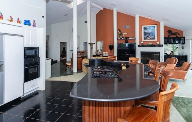 kitchen featuring high vaulted ceiling, dark tile floors, white cabinetry, and black appliances