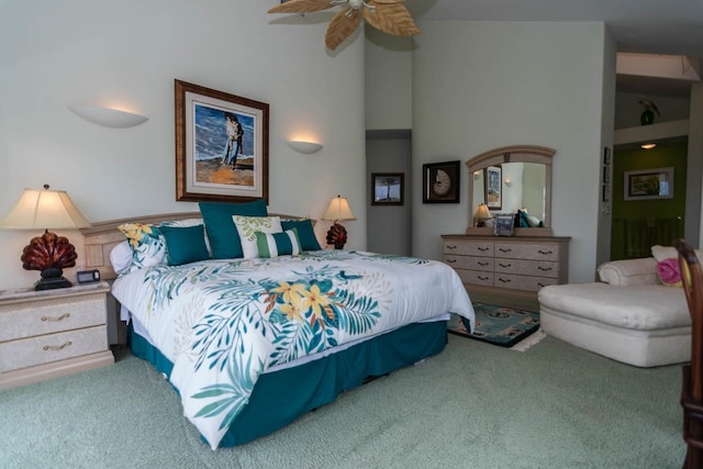 carpeted bedroom with ceiling fan and a high ceiling