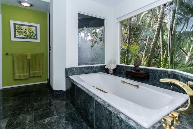 bathroom with tile floors and tiled bath