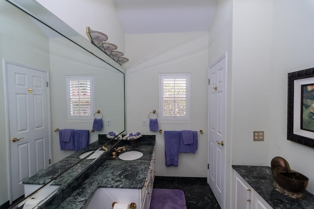 bathroom with tile flooring, plenty of natural light, oversized vanity, and lofted ceiling