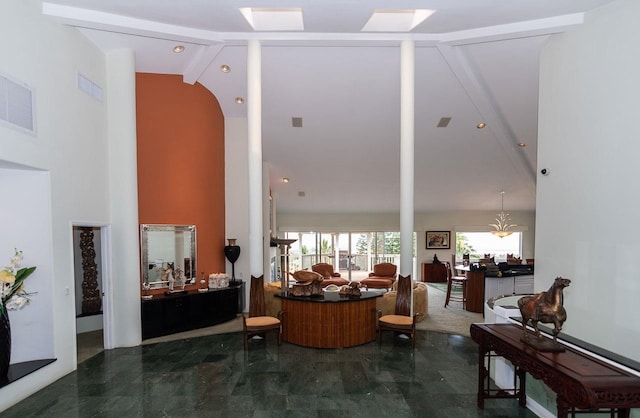 interior space featuring an inviting chandelier, beamed ceiling, tile floors, and high vaulted ceiling