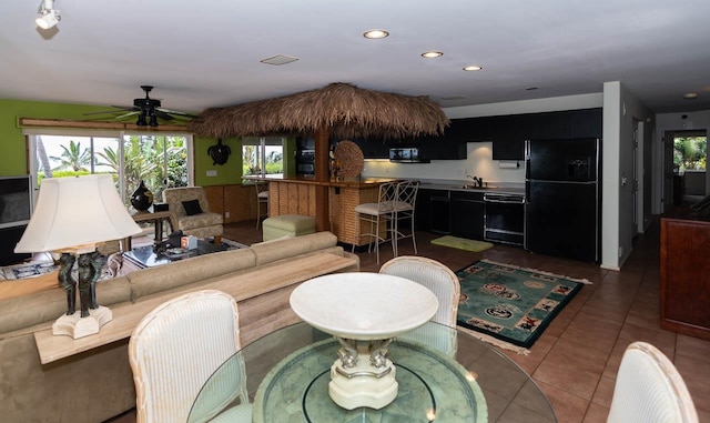 living room with sink, ceiling fan, tile floors, and a wealth of natural light