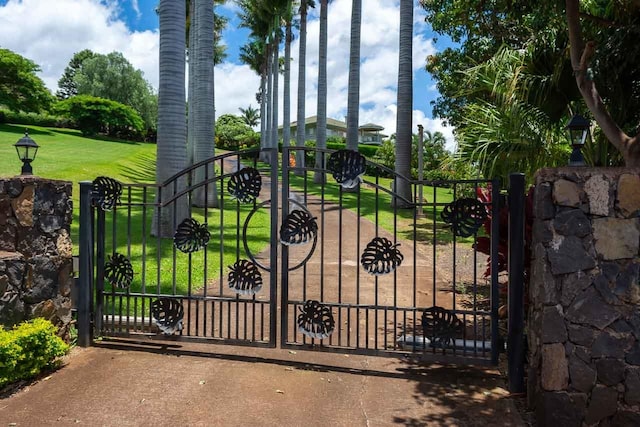 view of gate with a lawn