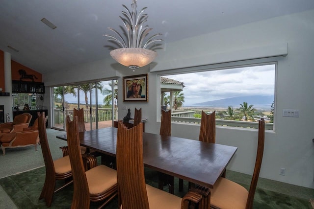 carpeted dining area with vaulted ceiling