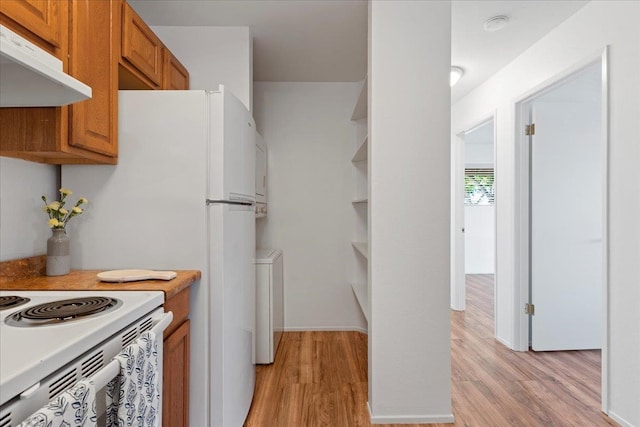 kitchen with electric range and light hardwood / wood-style flooring