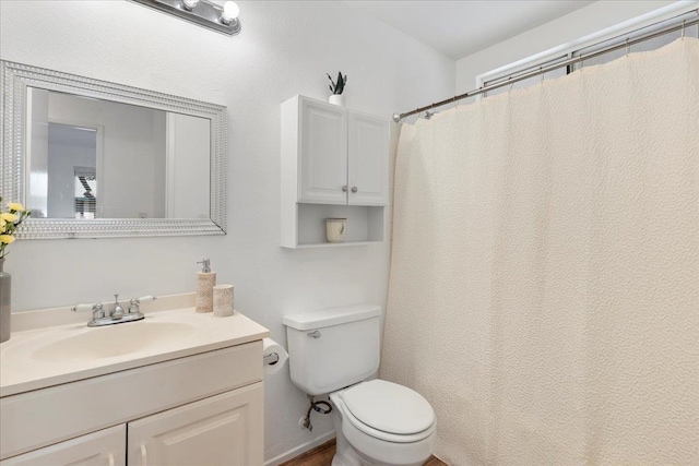 bathroom featuring vanity, a shower with shower curtain, and toilet