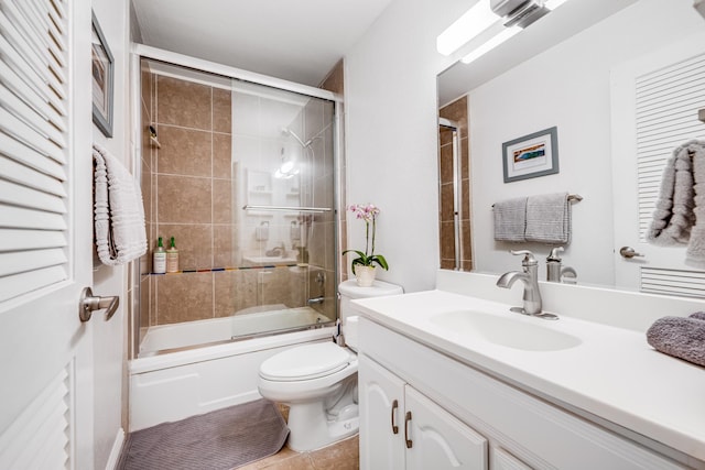 full bathroom featuring bath / shower combo with glass door, vanity, tile patterned flooring, and toilet