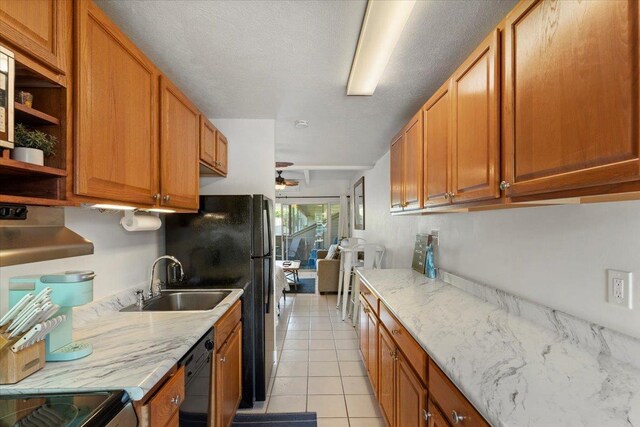 715 S Kihei Rd Unit D135, Kihei, HI 96753 - kitchen featuring a sink, black dishwasher, a ceiling fan, light tile patterned flooring, and light stone countertops