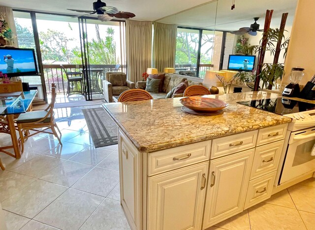 kitchen featuring ceiling fan, light tile flooring, and white range oven