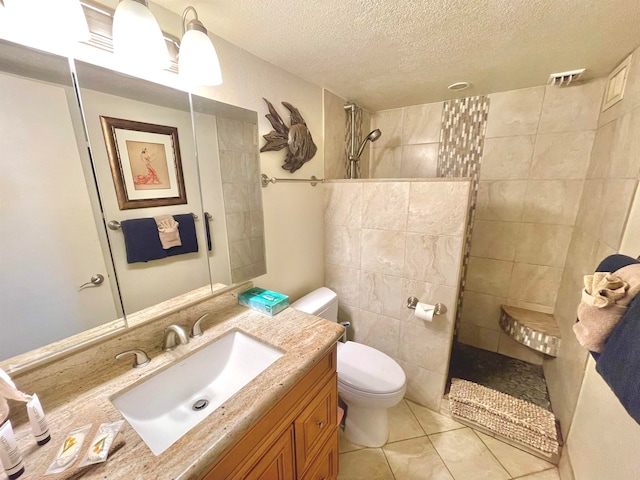 bathroom with tile walls, toilet, tile floors, a textured ceiling, and vanity