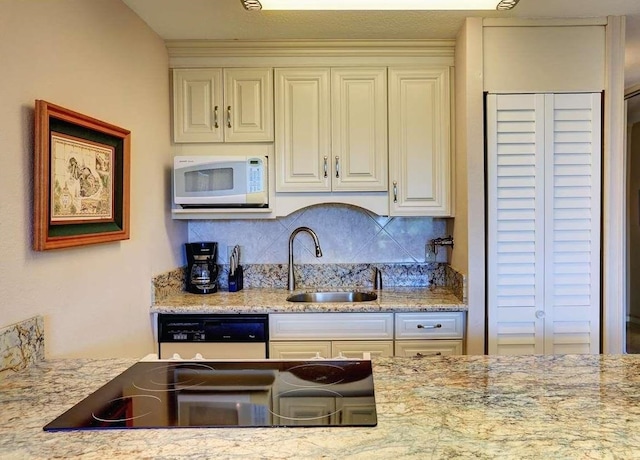 kitchen featuring sink, white appliances, tasteful backsplash, and light stone counters