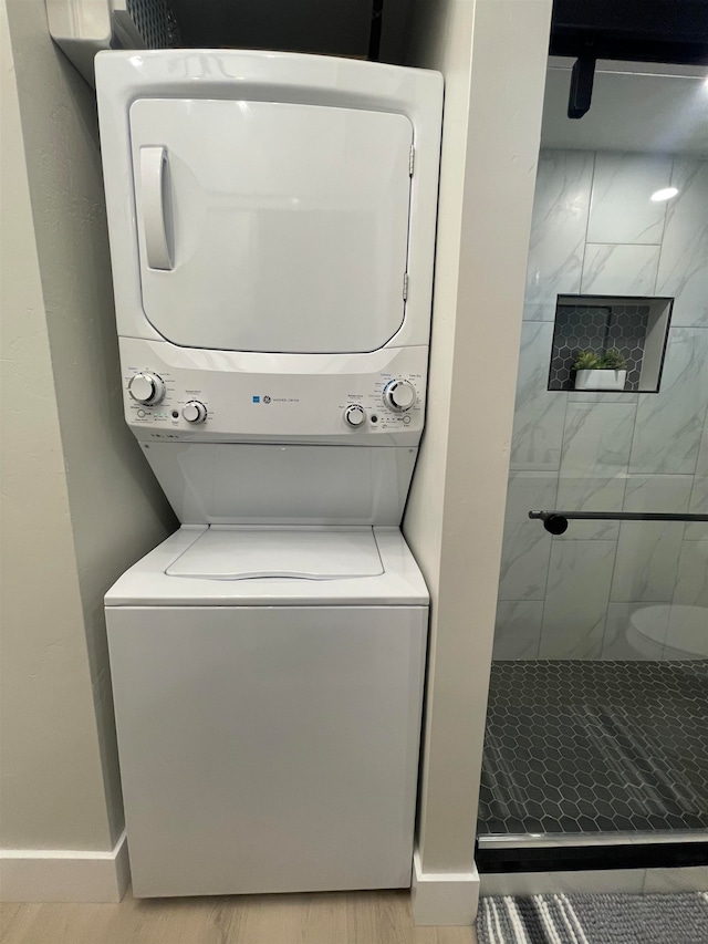 clothes washing area with light wood-type flooring and stacked washer and clothes dryer