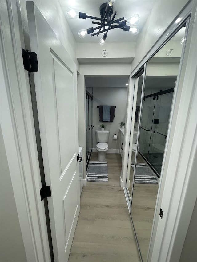 bathroom with toilet, wood finished floors, a shower stall, and vanity