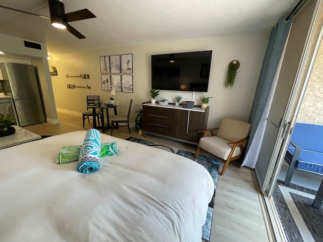 bedroom featuring ceiling fan, light hardwood / wood-style flooring, and stainless steel fridge