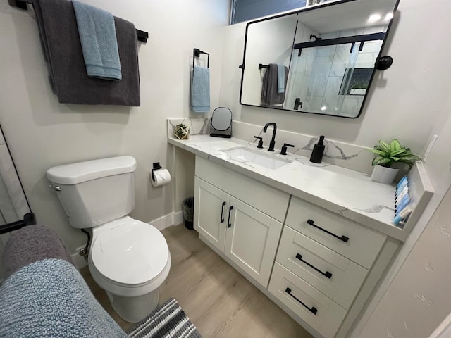 bathroom with vanity, toilet, a shower with door, and hardwood / wood-style flooring