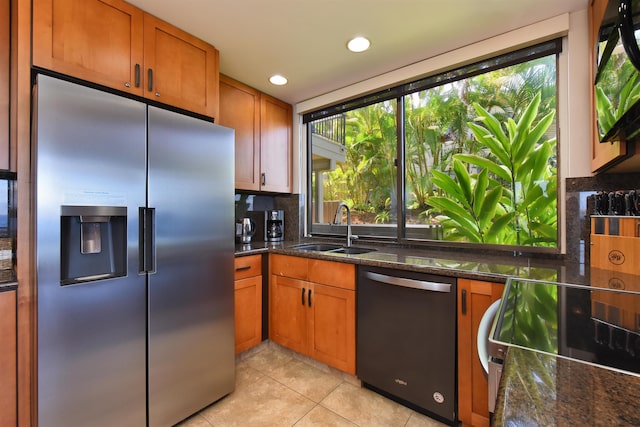 kitchen featuring decorative backsplash, stainless steel appliances, sink, and dark stone countertops