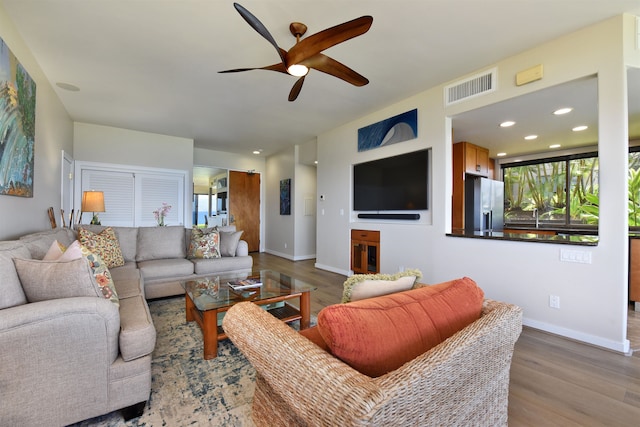 living room featuring light hardwood / wood-style flooring and ceiling fan