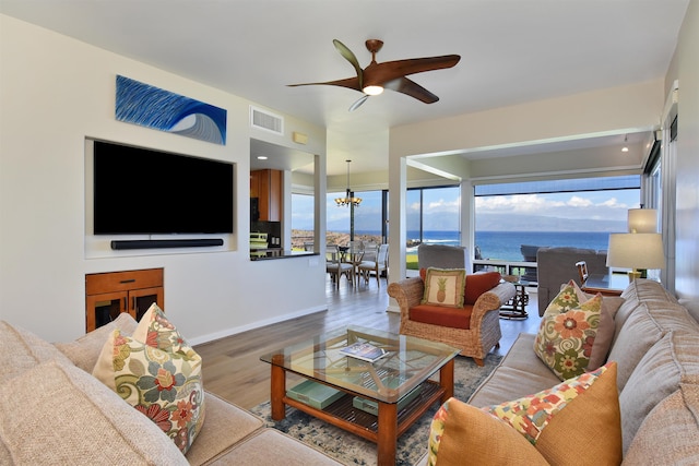 living room with hardwood / wood-style floors and ceiling fan with notable chandelier