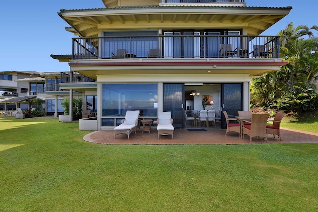 rear view of house featuring a patio, a balcony, and a yard