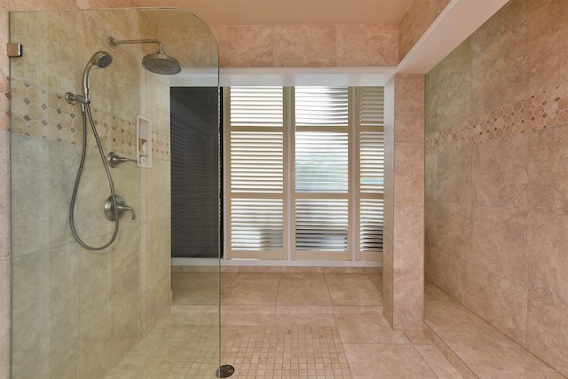 bathroom featuring tile patterned flooring and tiled shower