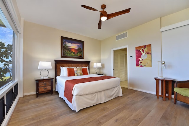 bedroom featuring light hardwood / wood-style flooring, ceiling fan, and a closet