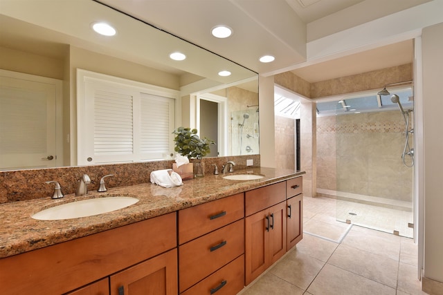 bathroom with vanity, tile patterned flooring, and tiled shower