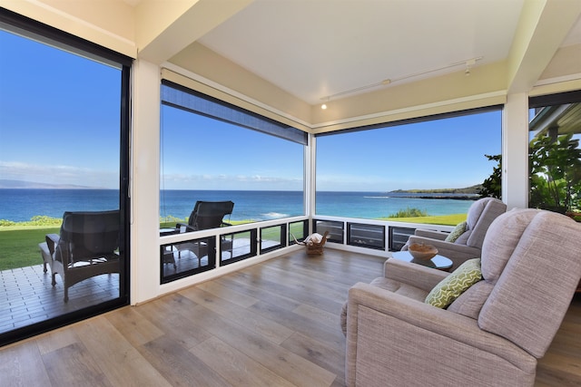 sunroom featuring a water view