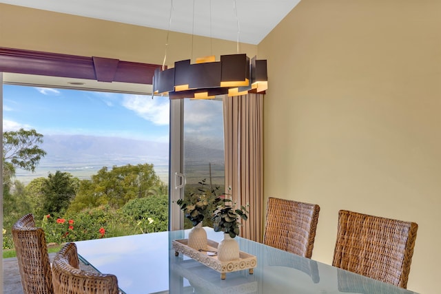 dining space with a mountain view and vaulted ceiling