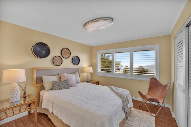 bedroom featuring a closet, light wood-type flooring, and baseboards