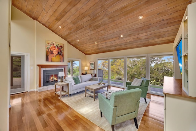 living area featuring a fireplace, light wood finished floors, recessed lighting, high vaulted ceiling, and wooden ceiling