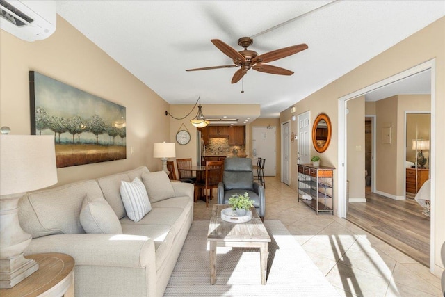 living room with ceiling fan, light hardwood / wood-style floors, and an AC wall unit