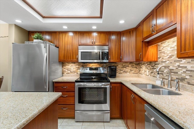 kitchen featuring sink, light tile patterned floors, tasteful backsplash, light stone counters, and stainless steel appliances