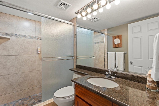 bathroom with vanity, a textured ceiling, toilet, and an enclosed shower