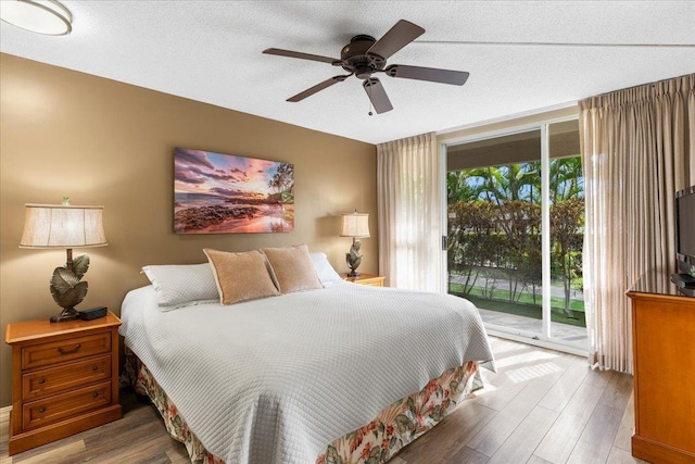 bedroom featuring access to exterior, hardwood / wood-style floors, a textured ceiling, and ceiling fan