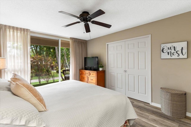 bedroom with light hardwood / wood-style flooring, ceiling fan, access to exterior, a textured ceiling, and a closet