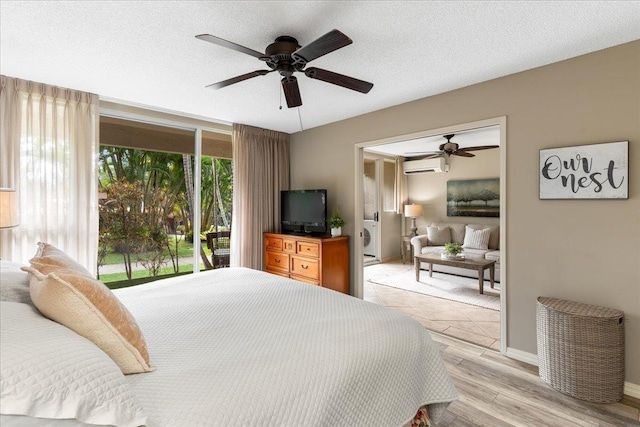 bedroom featuring ceiling fan, light hardwood / wood-style floors, a textured ceiling, and a wall unit AC