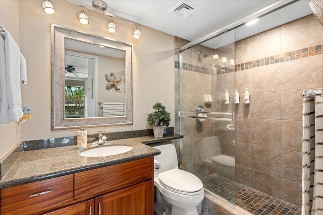 bathroom featuring ceiling fan, toilet, vanity, and walk in shower