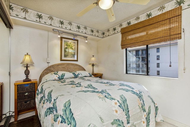 tiled bedroom featuring ceiling fan and a textured ceiling