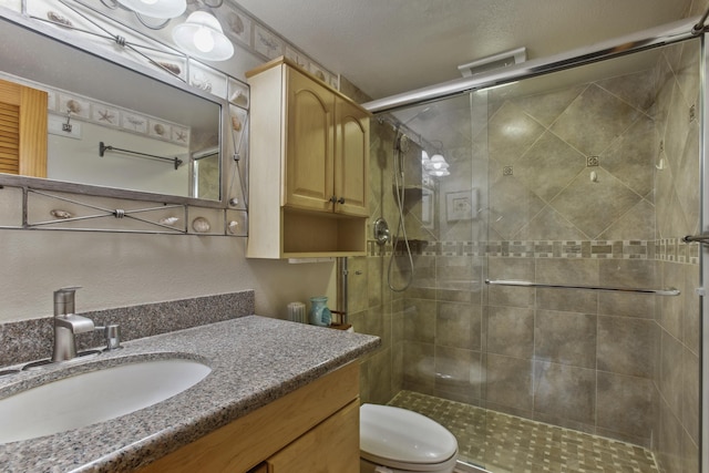 bathroom with toilet, an enclosed shower, and vanity