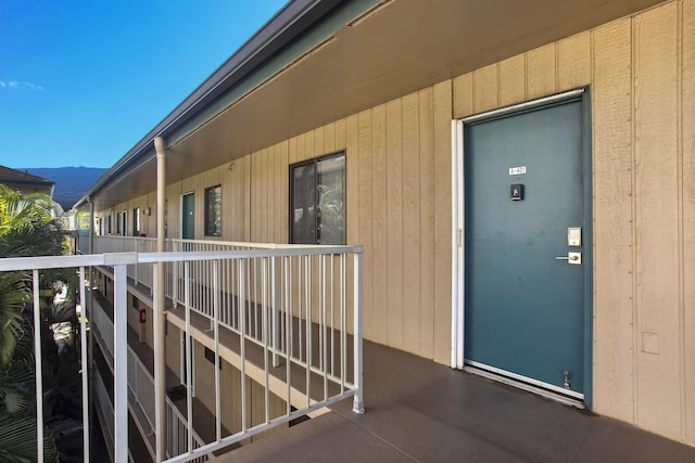 view of exterior entry with a mountain view and a balcony